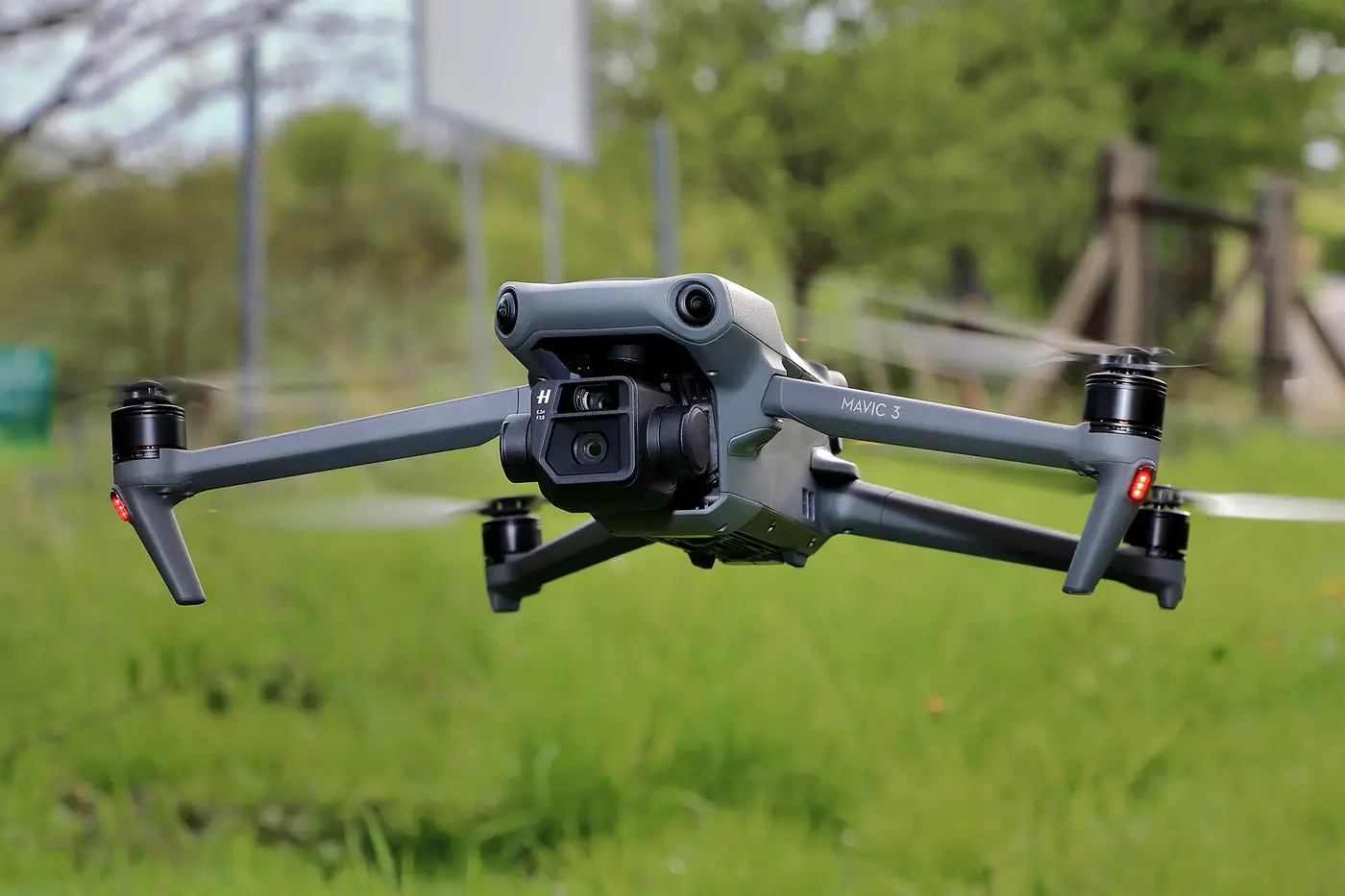 DJI Mavic 3 hovering low over a grass field