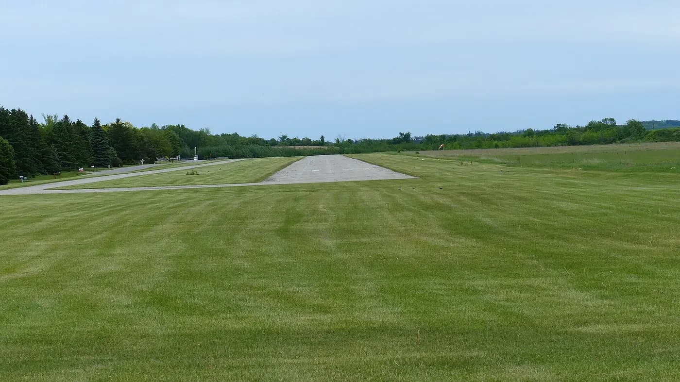 Grass-lined runway at a small airport under an open sky